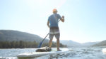 Photo of a man on a stand up paddle board out on the lake