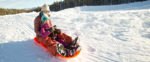 Background image of mother and daughter sledding