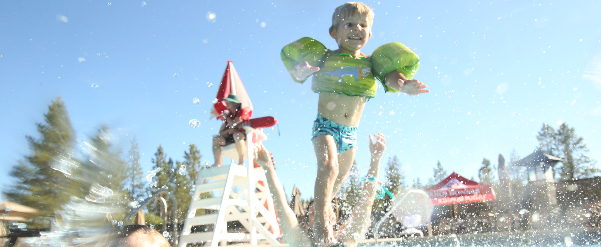 Child jumping into Trout Creek Rec Pool