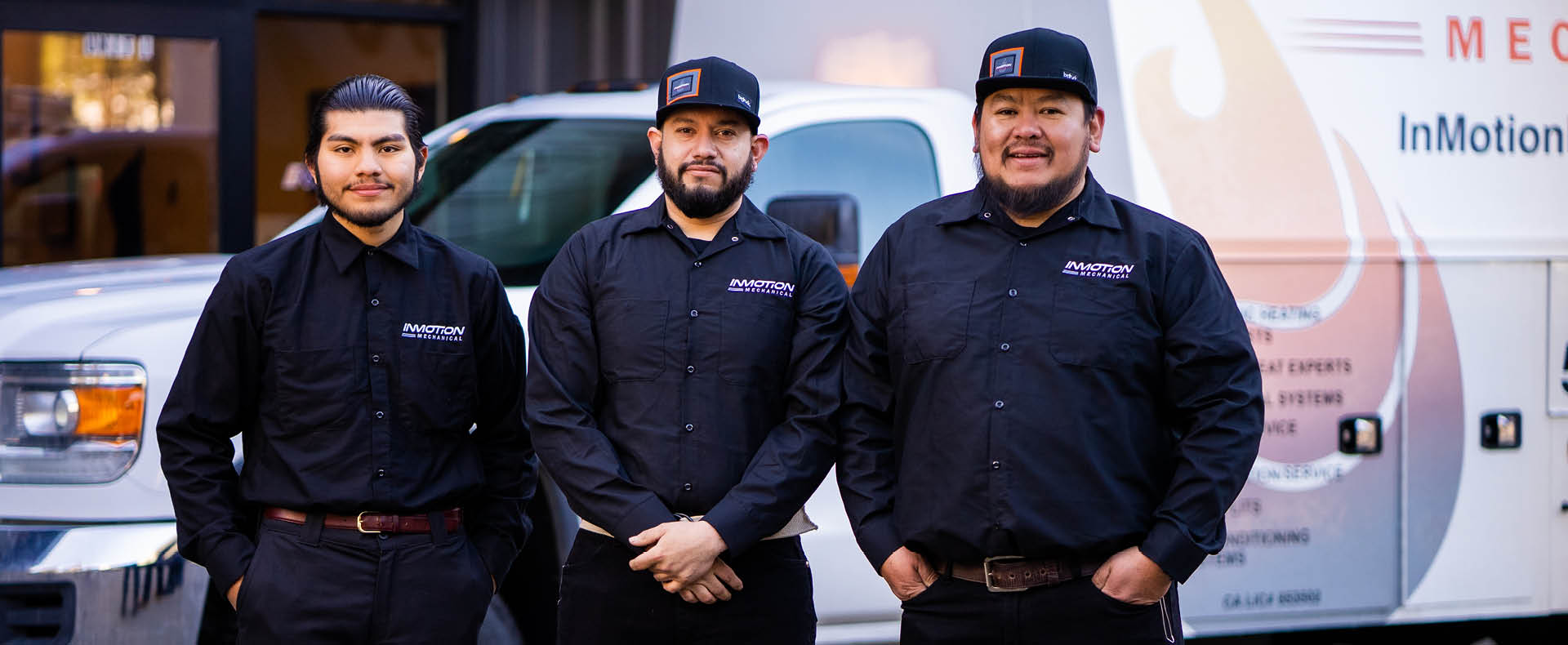 Three InMotion Mechanical employees standing by a company truck